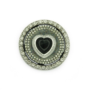 Macro detail of a spinning heart-shaped black gemstone with sparkling rhinestones inlay