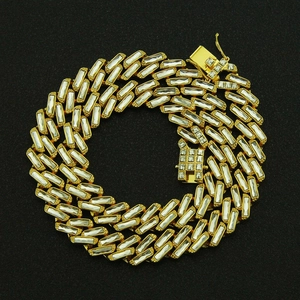 Macro detail of gold Cuban link chain with square multi-color crystals and secure box clasp