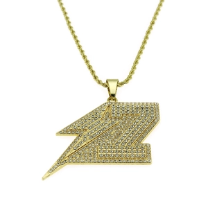 Détail du pendentif éclair Z avec diamants pavés et chaîne torsadée dorée style hip-hop