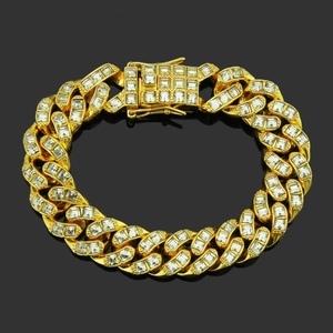 Gros plan d'un bracelet gourmette doré serti de zircons cubiques sur fond noir miroir