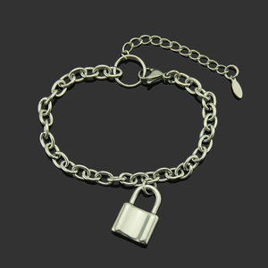 Minimalistische zilveren kettingarmband met gepolijste slot hanger op donkere reflectie