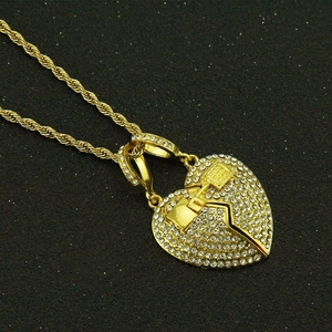 Detail of hip hop heart pendant with crystal pavé and hammer on gold twist chain