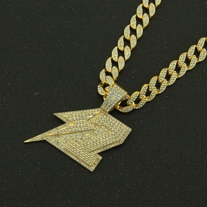 Macro shot of hip hop lightning pendant and iced out Cuban link chain with gold plating