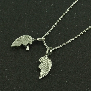 Macro detail of silver-toned hip hop broken heart pendant with honeycomb cutout back