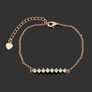 Bracelet minimaliste en or rose avec 8 oxydes de zirconium et un petit pendentif en cœur poli