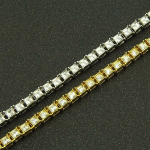 Macro detail of gold and silver hip hop tennis bracelets with square-cut cubic zirconia