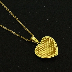 Détail du dos du pendentif cœur doré avec structure alvéolée et chaîne torsadée