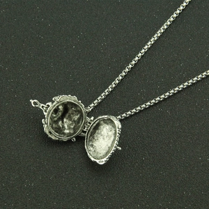 Vintage silver tiger urn necklace with embossed locket pendant on black background