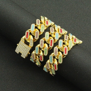 Collier Cuban Link en or hip hop avec strass colorés sur un support noir élégant