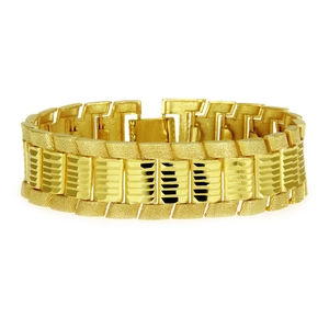 Macro view of wide gold curb chain bracelet showing matte and polished textures