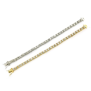 Close-up of gold and silver tennis bracelets with round-cut sparkling crystals on white base