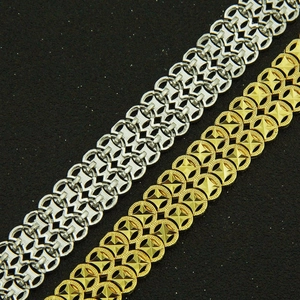 Detail of masculine gold and silver heavy metal links with intricate industrial patterns