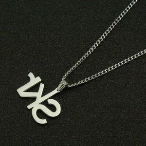 Vue détaillée du collier en acier inoxydable argenté avec un pendentif en forme de 1/2