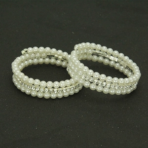 Detailed macro view of two-piece triple-layer pearl and rhinestone elastic bracelets