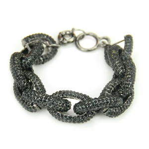 Gros plan d'un bracelet à gros maillons noirs pavé de petits strass brillants