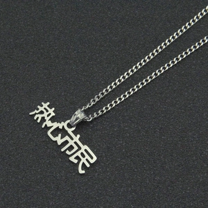 Gros plan d'un collier style urbain argenté avec pendentif lettre artistique et chaîne fine