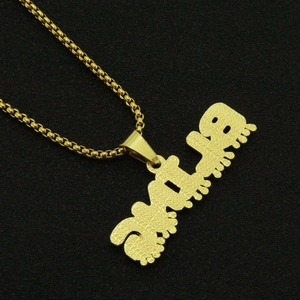 Détail d'une chaîne box dorée avec pendentif lettre GIRLS présentant des micro-gravures
