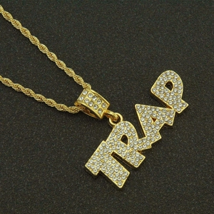Detailed view of gold-tone TRAP letter pendant with white rhinestones on twisted rope chain