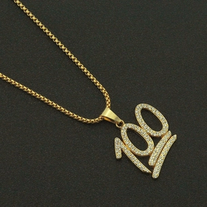 Macro shot of hip-hop gold necklace featuring a luxury iced-out number 100 pendant