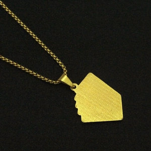 Gros plan détaillé du pendentif poker doré avec texture croisée sur fond noir uni