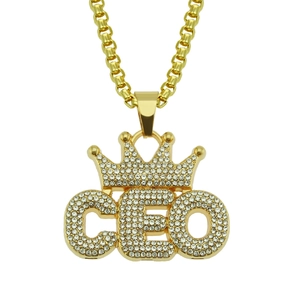 Détail macro du pendentif CEO doré avec couronne et strass en cristal blanc