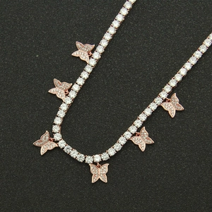 Macro detail of rose gold tennis necklace featuring cubic zirconia butterfly pendants