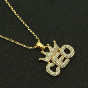 Collier pendentif CEO doré avec couronne et cristaux sur un fond noir texturé