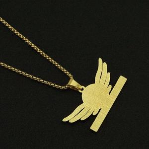 Detailed close-up of golden angel wing pendant with a polished finish and box chain