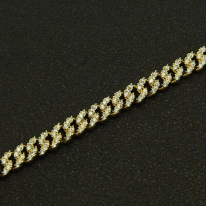 Détail macro du bracelet gourmette doré 8mm serti de zircons sur support noir