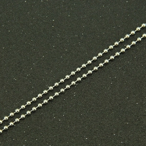 Detailed macro view of silver stainless steel ball chain with polished mirror finish texture