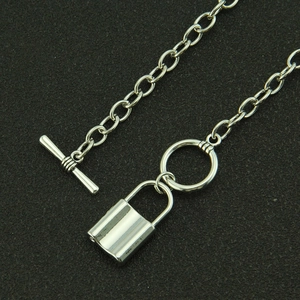 Polished silver lock pendant necklace with T-bar toggle clasp on textured black background