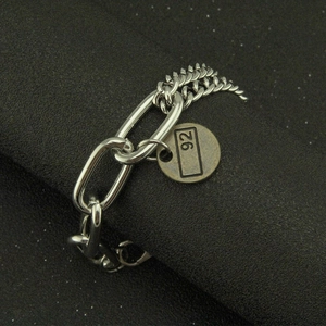 Silver Cuban link bracelet with oval rings and a round tag engraved with the number 92
