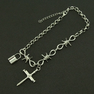 Minimalist silver thorn chain necklace featuring nail cross and lock cylinder pendants