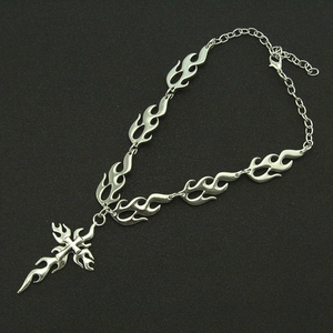 Collier style punk en acier inoxydable avec pendentif croix flamme sur fond noir texturé