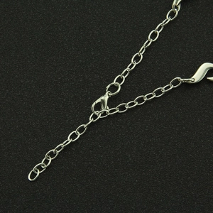 Gros plan du fermoir mousqueton réglable et de la chaîne d'extension du collier en argent
