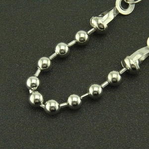 Macro detail of silver polished bead chain link with metallic clasp for street trousers
