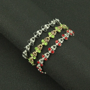 Three elegant rhinestone bracelets in silver and gold plating on black velvet stand