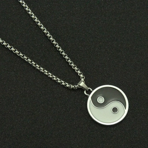 Detailed view of the Yin Yang Tai Chi pendant featuring black and white enamel finish