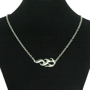 Detail of silver flame-shaped cutout pendant on a delicate chain displayed on a bust