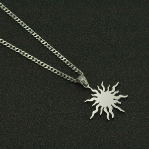 Polished stainless steel sun pendant necklace with curb chain on black background