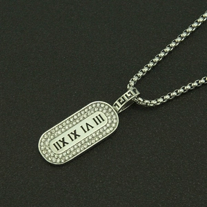 Close-up of silver roman numeral pendant with pavé crystals on a box chain