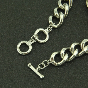 Bracelet gourmette punk hip hop argenté avec fermoir à bascule sur fond texturé noir