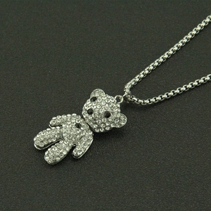Détail d'un collier pendentif ours argenté serti de strass brillants en micro-pavé