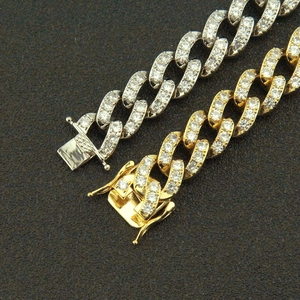 Détail de chaînes Cuban link 13mm or et argent avec sertissage de zircons scintillants