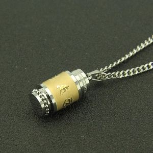 Vue macro du pendentif rotatif en acier inoxydable avec mantra bouddhiste or et argent