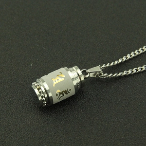 Détail macro du pendentif mantra en acier inoxydable avec finitions argent et or