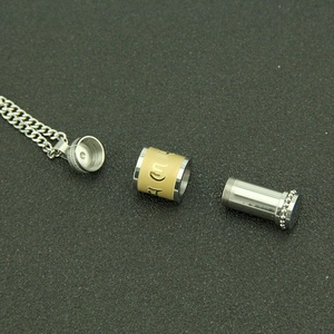 Vue démontée du pendentif mantra en acier inoxydable avec cylindre doré et chaîne en argent