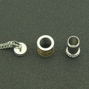 Détail du pendentif cylindrique bicolore en acier inoxydable avec gravure de mantra