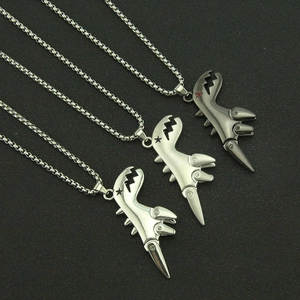 Vue détaillée de trois pendentifs dinosaures articulés en finitions métalliques punk argent