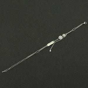 Macro detail of silver smile pendants and I BELIEVE engraved plate on titanium bracelet